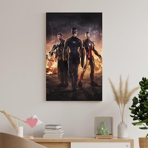 May include: A framed canvas print featuring three superheroes: Captain America, Iron Man, and Thor. The heroes are depicted in their iconic costumes, standing in front of a fiery background. The artwork has a dark, dramatic tone, suitable for a fan of comic book art.