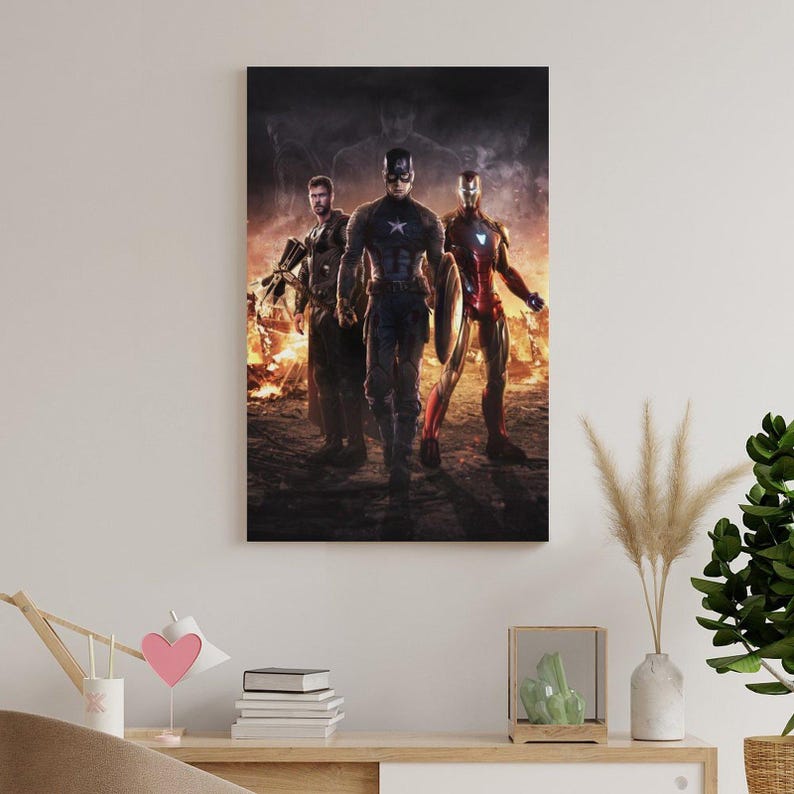 May include: A framed canvas print featuring three superheroes: Captain America, Iron Man, and Thor. The heroes are depicted in their iconic costumes, standing in front of a fiery background. The artwork has a dark, dramatic tone, suitable for a fan of comic book art.