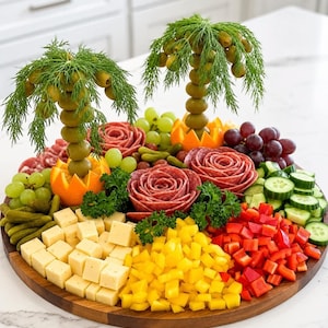 May include: A charcuterie board featuring two palm tree sculptures made of green olives and dill fronds, surrounded by salami roses, cubed yellow and white cheese, diced red bell peppers, sliced cucumbers, green grapes, and small pickles.