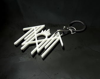 May include: A white, angular, geometric keychain featuring a stylized, interconnected design with a central circular element and radiating lines, attached to a silver-toned metal lobster clasp and a black circular split ring.