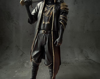 May include: A standing figurine of a hooded warrior wearing a black outfit with gold trim, a white mask with blue markings, and layered shoulder armor. The figure holds a sword over the right shoulder and wears multiple gold necklaces.