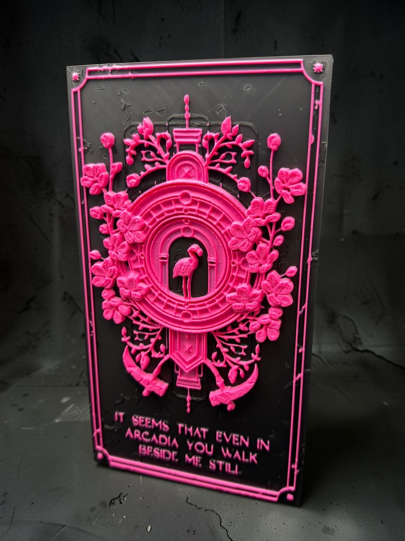 May include: A rectangular black plaque featuring a raised neon pink relief design. The center displays a flamingo inside an arched frame surrounded by floral motifs and two scythes. The text reads: IT SEEMS THAT EVEN IN ARCADIA YOU WALK BESIDE ME STILL.