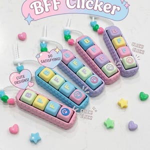 May include: Four rectangular mechanical clicker keychains in pastel pink, blue, purple, and lavender. Each features four square keys labeled B, F, F, and a smiley face. The text BFF Clicker, SO SATISFYING, CLICK! CLICK!, and LOVE! The perfect friendship gift! appears.