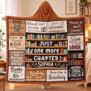 May include: A brown hooded fleece blanket featuring a grid of book-themed illustrations and text including "Books are my valentine," "Read fast live slow," "I am a bookaholic," "Just one more chapter," "Sophia," and "Books full open you fall in."