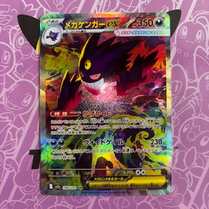 Peut inclure: Une carte à collectionner Pokémon holographique représentant un Mega Gengar ex. La carte a une palette de couleurs violet et noir avec du texte japonais. La carte est sur un fond violet avec un personnage de dessin animé.