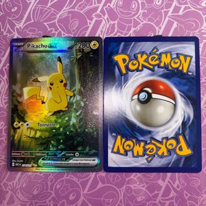 Może przedstawiać: Karta kolekcjonerska Pikachu EX przedstawiająca żółtą postać w leśnym otoczeniu obok standardowej karty Pokémon z niebieskim rewersem i centralną grafiką czerwono-białej kuli. Karta zawiera tekst Pikachu EX, 200 HP oraz Tonnerre.