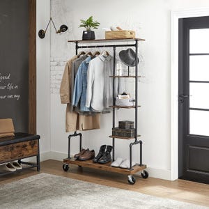 Puede incluir: Un perchero con ruedas construido con tuberías de metal negro y estantes de madera oscura. La unidad cuenta con una barra para colgar ropa, cuatro estantes laterales para almacenamiento y un estante superior para diversos artículos.