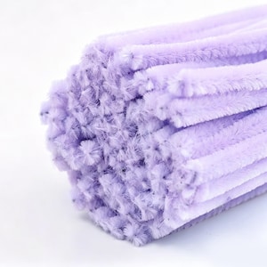 May include: A bundle of light purple pipe cleaners, also known as chenille stems. The fuzzy, flexible craft sticks are arranged together, showcasing their soft, textured surface and uniform lavender color throughout the entire collection.
