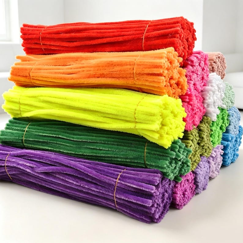 May include: A large collection of fuzzy pipe cleaners arranged in horizontal stacks. The bundles feature a vibrant spectrum of colors including red, orange, yellow, green, purple, pink, white, and blue, each secured with a thin brown band.