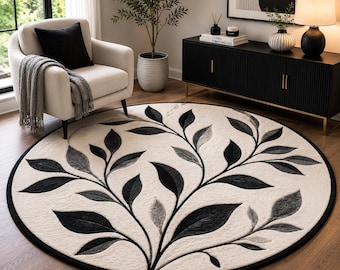 Tappeto rotondo in lana con motivo botanico, foglie nere e avorio, realizzato a mano con tecnica tufting, tappeto moderno ispirato alla natura.