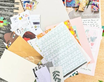 May include: A collection of art journaling supplies, including a blank notebook with stamps, patterned papers, envelopes, and cards. The image includes the text "Art Journaling" and "I around you. Browse art als to use that can Having a journal can to put your".