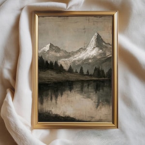 Può includere: Dipinto di paesaggio incorniciato con montagne innevate riflesse in un lago calmo. L'opera d'arte è in tonalità tenui di grigio, bianco e marrone, con una cornice dorata. Il dipinto evoca un senso di tranquillità e bellezza naturale.