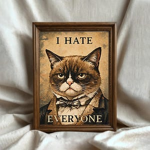 Può includere: Stampa incorniciata con un gatto scontroso con papillon e giacca. Il testo "I HATE EVERYONE" è visualizzato sopra e sotto l'immagine del gatto. La cornice è di colore marrone scuro.