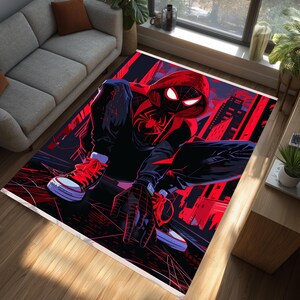 May include: Rectangular area rug featuring a dynamic illustration of a superhero in a red and black suit, set against a cityscape backdrop. The rug has a white border and is placed on a wooden floor.