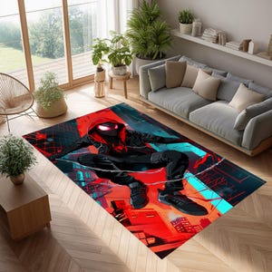 May include: A rectangular area rug featuring a superhero in a black and red suit, posed in a dynamic action stance. The rug's design incorporates a cityscape backdrop with vibrant red, blue, and black colors. The rug is placed on a wooden floor in a living room setting.