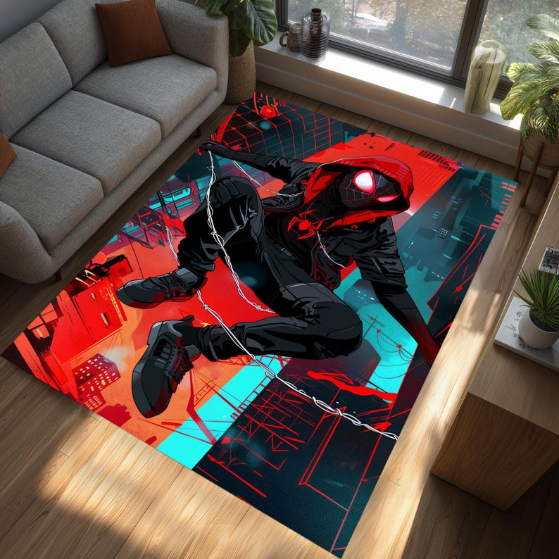 May include: A rectangular area rug featuring a dynamic illustration of a superhero in a black suit with a red hood. The rug's background is a vibrant cityscape in red, blue, and black, creating a bold and energetic design.