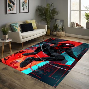May include: A rectangular area rug featuring a dynamic illustration of a superhero in a red and black suit, set against a cityscape with red and teal accents. The rug is placed on a wooden floor.