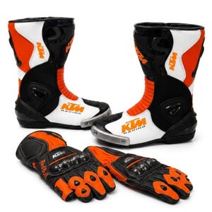 May include: A pair of black, white, and orange motorcycle boots featuring the KTM Racing logo and a pair of matching black and orange motorcycle gloves with Red Bull branding, protective knuckle guards, and reinforced finger padding.