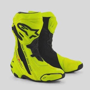 Puede incluir: Un par de botas de carreras para motocicleta en color amarillo neón y negro con diseño de corte alto, protección reforzada en el tobillo y el logotipo de Alpinestars en el lateral. Incluyen paneles texturizados y una suela resistente.