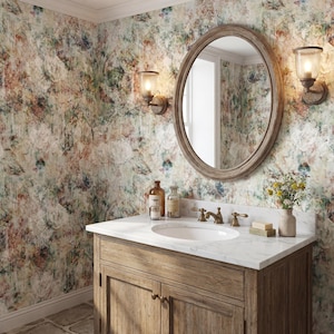 May include: A bathroom with a wooden vanity, oval mirror, and floral wallpaper. The vanity has a marble countertop, a white sink, and brass fixtures. Two sconces flank the mirror, and a small vase of flowers sits on the counter.