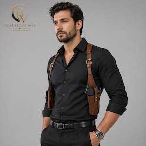 May include: Brown leather shoulder holster with a gun, worn over a black button-down shirt. The holster has adjustable straps and metal buckles. The image also shows a black belt and a watch.