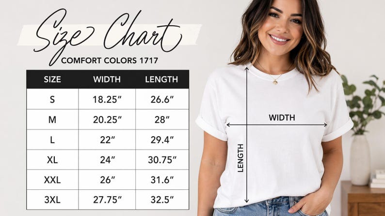 A woman is standing next to a size chart for a white t-shirt, smiling and posing for the camera.