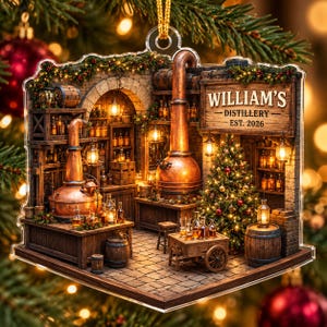 May include: A clear acrylic Christmas ornament featuring a detailed distillery scene with copper stills, wooden barrels, and shelves of bottles. A sign reads WILLIAM'S DISTILLERY EST. 2026. A decorated Christmas tree stands in the corner with warm lighting.