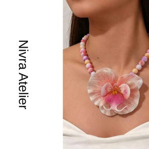 Collar con colgante de orquídea rosa y cuentas en tonos pastel con diseño floral llamativo.