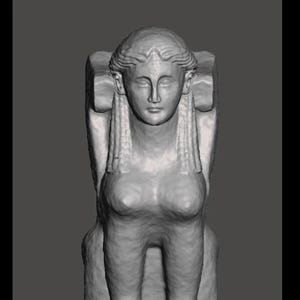 Puede incluir: Una escultura gris de una esfinge con cabeza humana y cuerpo de león. La esfinge está sentada, con las patas extendidas hacia adelante. La escultura tiene rasgos faciales detallados y cabello largo.