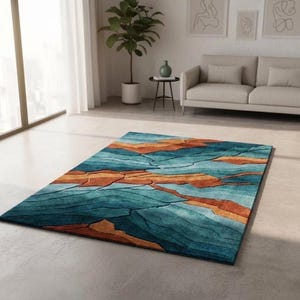 May include: A rectangular area rug featuring a textured, abstract landscape pattern with deep teal, blue, and burnt orange color blocks separated by dark, carved-look lines that create a layered, topographical appearance across the surface.