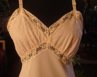 Puede incluir: Una camisola blanca con delicado bordado floral y ribete de encaje. La camisola tiene tirantes ajustables y un escote en V.