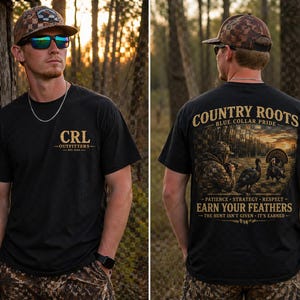 Pode incluir: Camiseta preta com a inscrição dourada "CRL OUTFITTERS" na frente. A parte de trás apresenta uma cena de caça com o texto "COUNTRY ROOTS BLUE COLLAR PRIDE" e "EARN YOUR FEATHERS". A pessoa está usando um boné camuflado e óculos de sol.