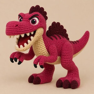 May include: A crocheted dinosaur toy in shades of red, beige, and black. The dinosaur has an open mouth with white teeth, large eyes, and a spiky crest. The toy is handmade and has a detailed, textured appearance.