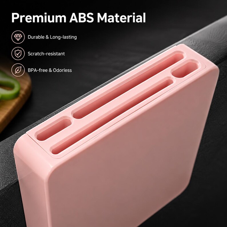 May include: A light pink rectangular knife block made of ABS material with multiple slots for kitchen knives. The text Premium ABS Material is visible, along with icons and labels for Durable & Long-lasting, Scratch-resistant, and BPA-free & Odorless.