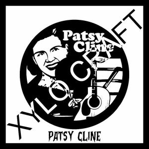 Op de afbeelding: Zwart-wit grafische afbeelding met Patsy Cline in een cirkel. Het ontwerp bevat een gitaar, muzieknoten en de tekst "Patsy Cline" en "XYLO CRAFT". De achtergrond is zwart.