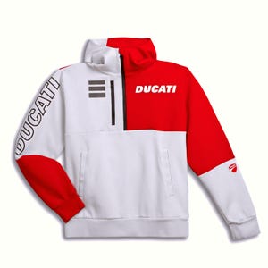 Puede incluir: Una sudadera blanca y roja con cuello alto y cierre de cremallera parcial. La palabra DUCATI está impresa en blanco en el panel rojo del pecho y en negro en la manga derecha. Un pequeño logotipo de Ducati es visible en la manga izquierda.