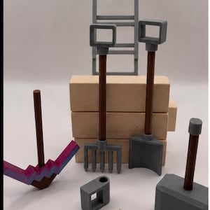 May include: A collection of miniature toy tools including a gray ladder, a wooden block stack, a purple and blue pickaxe, a gray rake, a gray shovel, a gray hammer, a small gray square block, and a gray four-pronged hook attached to a beige string.