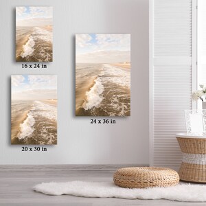 Pu&ograve; includere: Stampe artistiche di paesaggi costieri in varie dimensioni, tra cui 20 x 30 pollici (50.8 x 76.2 cm) e 24 x 36 pollici (60.96 x 91.44 cm). L'opera raffigura onde che si infrangono su una spiaggia sabbiosa sotto un cielo nuvoloso.