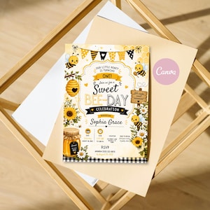 May include: A rectangular birthday invitation card featuring a yellow and black bee theme. The text reads: Our Little Honey Is Turning One! Join us for a Sweet Bee-Day Celebration honouring Sophia Grace. Includes date, time, location, and RSVP details.