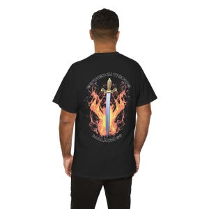 May include: Black t-shirt with a graphic design on the back. The design features a sword in front of flames, with the text "REFINED IN THE FIRE" and "MALACHI 3:3" in a circular pattern.