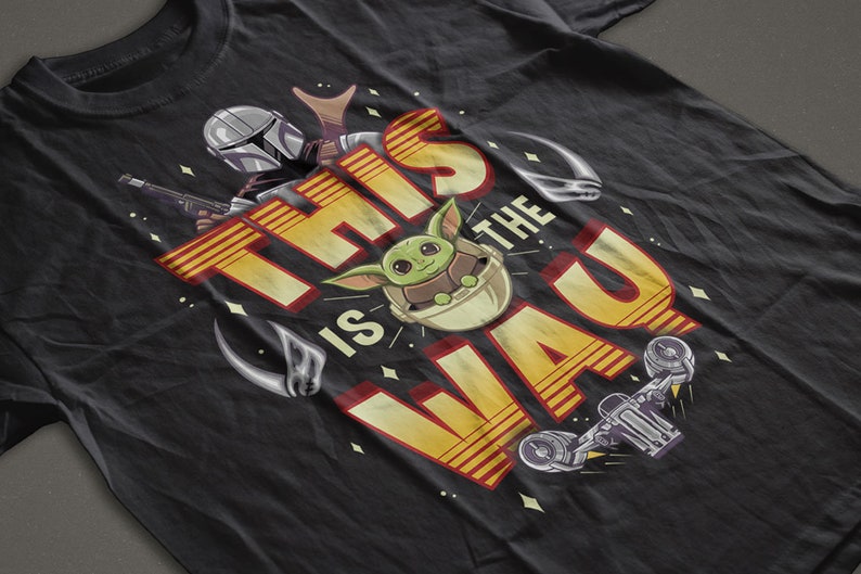 Może przedstawiać: Czarny T-shirt z ż&oacute;łto-czerwonym nadrukiem przedstawiającym tekst "This is the Way" z kresk&oacute;wkową postacią zielonego kosmity i postacią Mandalorianina.