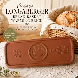 May include: A brown Longaberger bread basket warming brick. The rectangular brick has the words "Bread Basket Brick" and "Use with Extreme Care When Hot" embossed on it. The image also shows a bread basket with bread.