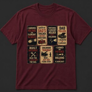 May include: Maroon t-shirt with a humorous design featuring text and illustrations about dads and flashlights. The design includes phrases like "I survived holding the flashlight for dad" and "Childhood trauma? Nah... just dad fixing stuff."