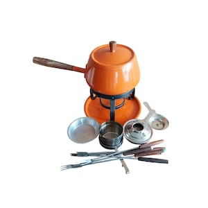 May include: An orange fondue pot set with a wooden handle and lid. The set includes a black metal stand, a warming tray, and various serving utensils, including forks and small metal dishes. The fondue pot is a classic design, perfect for entertaining.