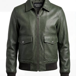 Puede incluir: Chaqueta de cuero verde oscuro con cierre de cremallera, dos bolsillos delanteros y dobladillo y puños de canalé. La chaqueta tiene cuello y el texto "MAVERICK JACKET" es visible en la etiqueta.