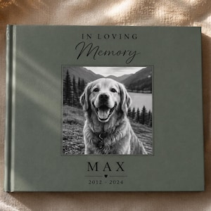Op de afbeelding: Een saliegroen fotoboek met harde kaft en de tekst IN LOVING MEMORY bovenaan. In het midden staat een zwart-witfoto van een hond. Onder de foto staat de naam MAX gedrukt met een klein hartje en de jaartallen 2012 - 2024.