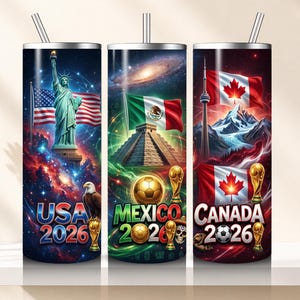 May include: Three stainless steel insulated tumblers with straws. Each tumbler features a unique design: the Statue of Liberty with the American flag, a Mexican pyramid with the Mexican flag, and the Canadian flag with the CN Tower. The text "USA 2026", "MEXICO 2026", and "CANADA 2026" are displayed.