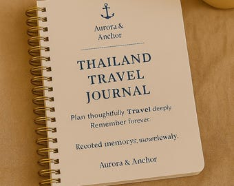 May include: A spiral-bound journal with a cream-colored cover featuring the text "THAILAND TRAVEL JOURNAL" in navy blue. The cover also includes an anchor graphic and the words "Aurora & Anchor". The journal is designed for travel planning and memory keeping.