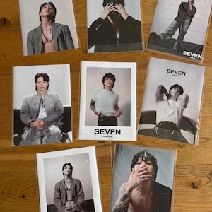 Könnte beinhalten: Eine Sammlung von sieben Fotokarten mit einem männlichen Model in verschiedenen Posen. Jede Karte trägt das Wort "SEVEN" oben, darunter der Name "Jung Kook". Die Bilder sind in Schwarzweiß und Farbe.
