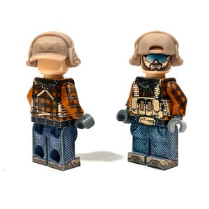 May include: Two Lego minifigures, each wearing a tan helmet, orange plaid shirt, blue jeans, and a tactical vest. One figure has goggles and a beard. The figures have gray hands.